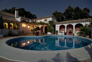 A dream home mansion looking over a large swimming pool