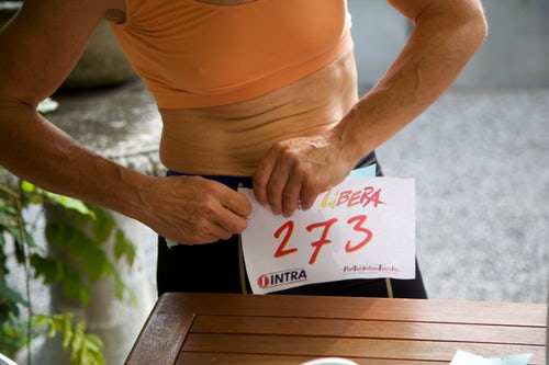 Runner pinning race number onto leggings while getting fit